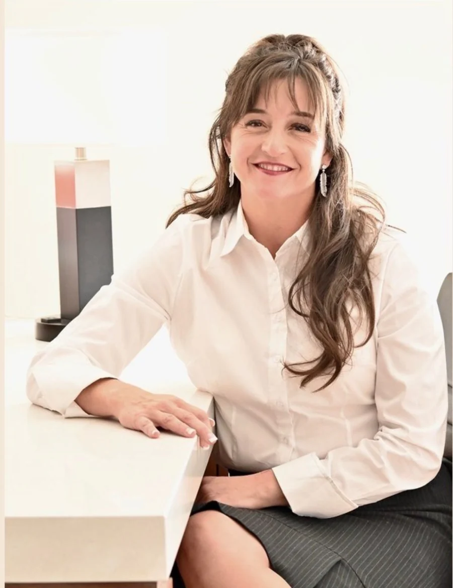 Carla Puentes seated in a white shirt